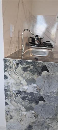 a kitchen counter with a sink and a stove at Mirador del Molino in Fusagasuga