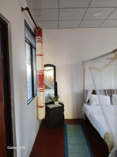a bedroom with a bunk bed and a mirror at Kumari villa in Weligama