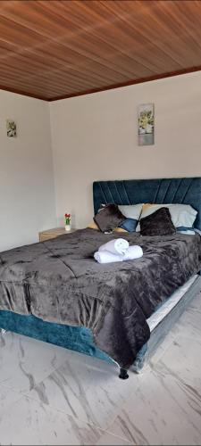a bedroom with a large bed with a black comforter at Mirador del Molino in Fusagasuga