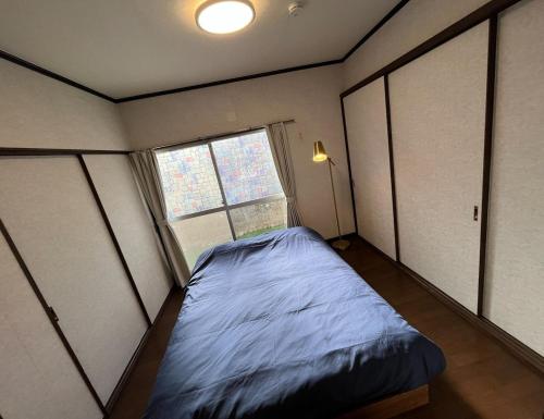 ein kleines Schlafzimmer mit einem Bett und einem Fenster in der Unterkunft Entire house for rent in Beppu with a dog run in Beppu