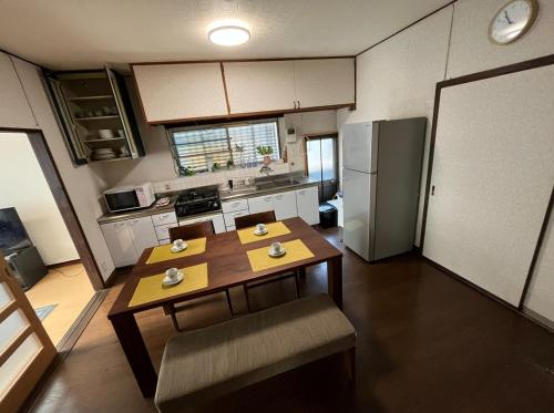 eine kleine Küche mit Tisch und Kühlschrank in der Unterkunft Entire house for rent in Beppu with a dog run in Beppu