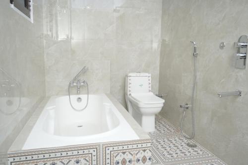 a bathroom with a toilet and a sink and a shower at Hotel Karni Niwas in Jaipur