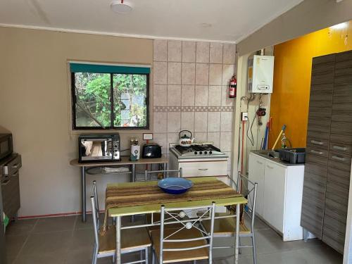 een kleine keuken met een tafel en een fornuis bij casa en el lago in Contulmo