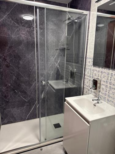 un baño con ducha y lavabo en Hostal La Sierra Cabárceno, en Sarón