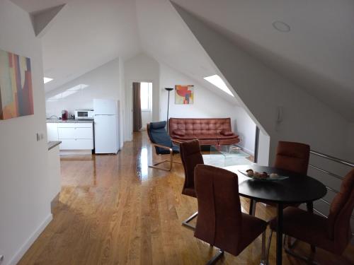 a living room with a couch and a table and chairs at Ares do mar - Loft and terrace in Matosinhos