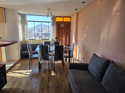 ein Wohnzimmer mit Sofa, Tisch und Stühlen in der Unterkunft Apartamento centrico en Puno in Puno