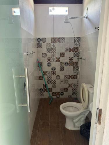 a bathroom with a toilet and a shower at Pousada Cachoeira in Itambé do Mato Dentro