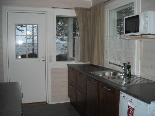 ポシオにあるAneen Loma Vacation and Cottagesのシンクと電子レンジ付きのキッチン