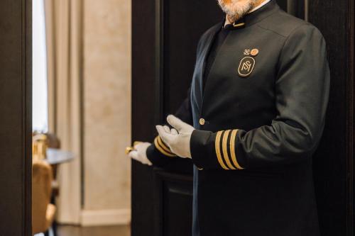 Ein Mann im Anzug steht in einer Tür in der Unterkunft MYTHIC SANA Downtown Suites in Lissabon