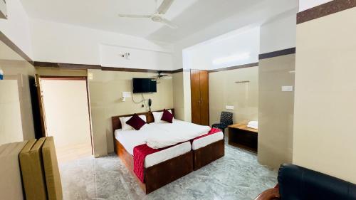 a hotel room with a bed and a tv at Hotel Anbu Airport in Chennai