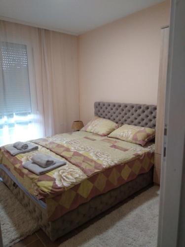 een slaapkamer met een bed in een kamer met een raam bij Apartman,,Petko,, in Bajina Bašta