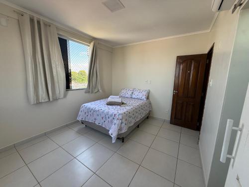 una piccola camera da letto con un letto e una finestra di Apartamento com duas suítes! a Macapá