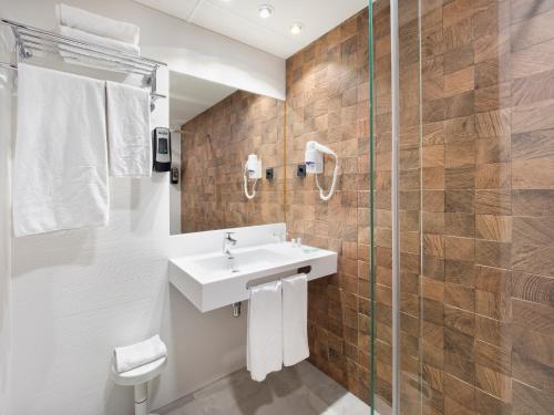 La salle de bains est pourvue d'un lavabo et d'une douche. dans l'établissement Hotel Zentral Parque, à Valladolid