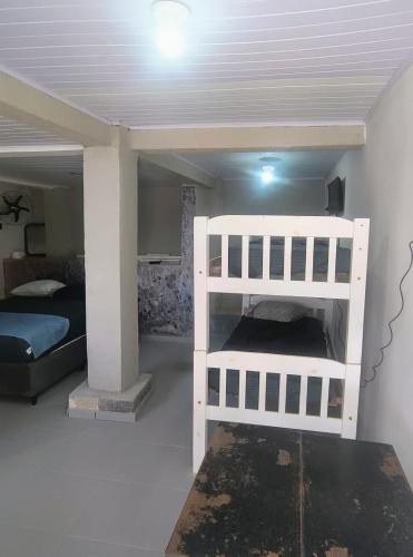 a bedroom with a white bunk bed in a room at Jade Beach Club in São Vicente