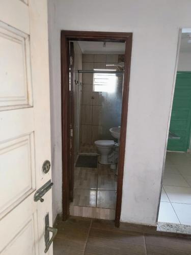 a bathroom with a toilet and a door to a room at Jade Beach Club in São Vicente