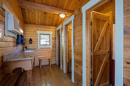 Eine Blockhüttenküche mit Holzwänden und einer Tür in der Unterkunft Texas Hill Country Resort in Medina
