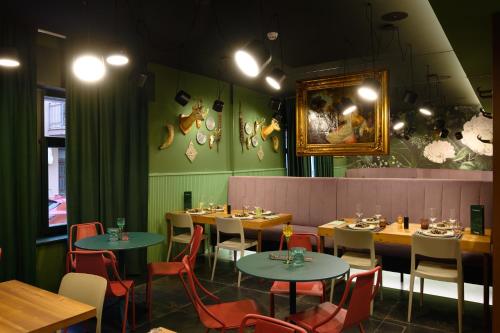 een eetkamer met tafels en stoelen en een schilderij aan de muur bij Franz Apartments in Ilirska Bistrica