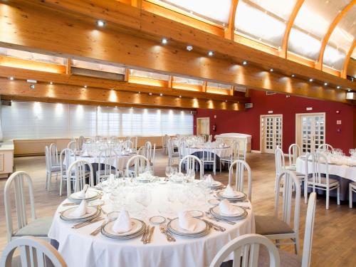 a banquet hall with white tables and chairs at Hotel Zentral Parque in Valladolid