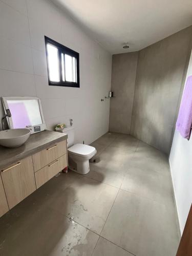 a bathroom with a toilet and a sink and a window at Casa Brisa em Touros in Touros