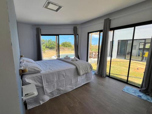 a bedroom with a bed and large windows at Casa Brisa em Touros in Touros