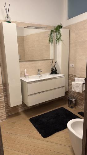 een badkamer met een bad, een wastafel en een spiegel bij Bon Bon Il Brofferio in Asti