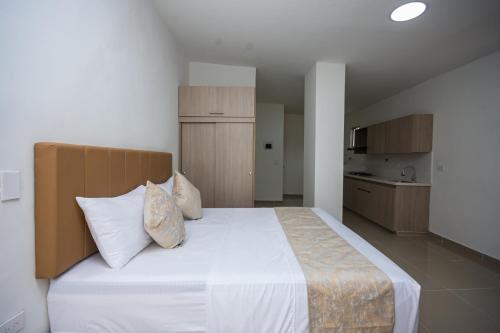 a bedroom with a large white bed with pillows at Apartahotel Ceo in Medellín