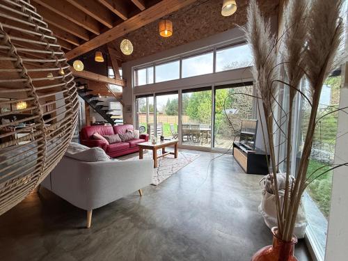 ein Wohnzimmer mit Sofa und Tisch in der Unterkunft La Verrière - maison écologique normande 