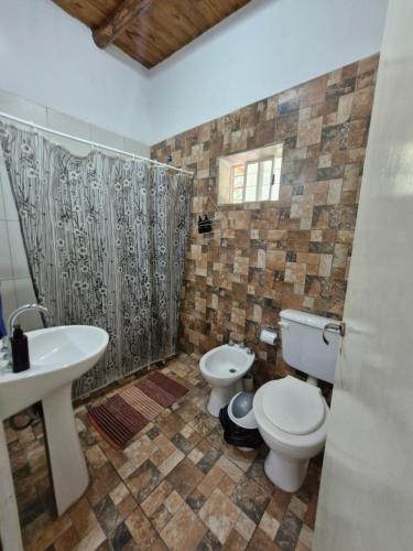 a bathroom with two toilets and a sink at Cabañas El Sauce in Albardón