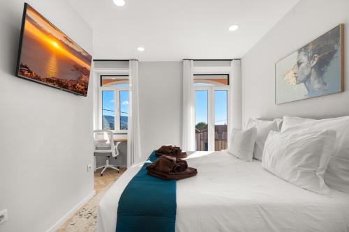 a white bedroom with a white bed and two windows at Casa NOLA by Susys Holidays in Funchal