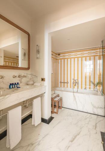 a bathroom with two sinks and a tub and a mirror at Splendido Mare, A Belmond Hotel, Portofino in Portofino