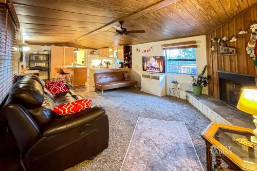 a living room with a leather couch and a television at Ruidoso Mountain Getaway Centrally Located in Ruidoso