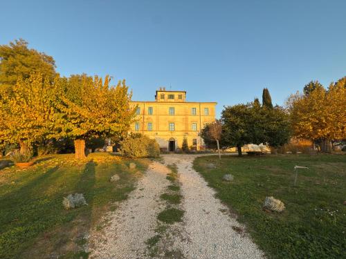 a dirt road leading to a large yellow building at Casale Malatesta in Velletri
