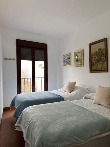 twee bedden in een kamer met witte muren bij Apartamento La Constitución in Luque