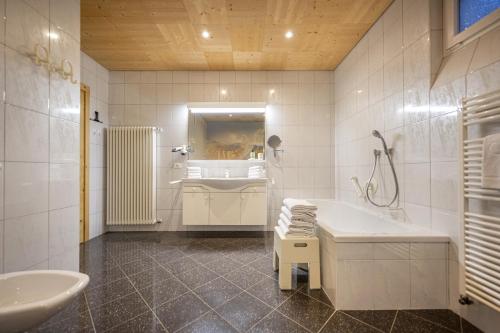 een badkamer met een wastafel, een bad en een douche bij Apartments Romy in Ortisei