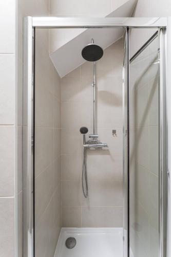 a shower with a glass door in a bathroom at Artistas House in Aveiro