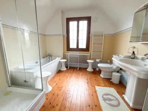 ein Badezimmer mit Badewanne, Toilette und Waschbecken in der Unterkunft Maison avec jardin dans le centre de Cabourg in Cabourg