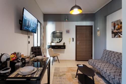 Una sala de estar con un sofá, una mesa y un televisor. en Agnanti Apartment, en Agrinio