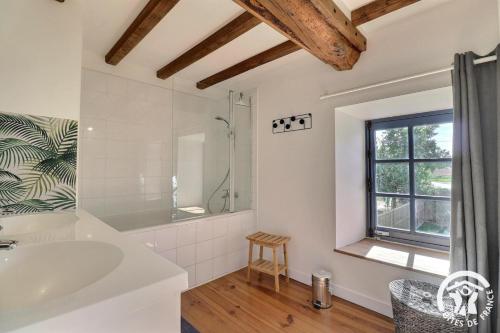 un bagno bianco con vasca e lavandino di Quinfromel a Pleumeleuc