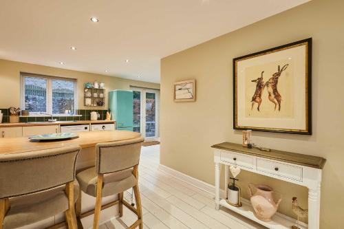 a kitchen with a dining table and a painting on the wall at Host and Stay - 36 Hardy Meadows in Grassington