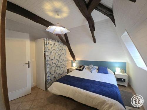 une chambre avec un lit bleu et blanc dans un grenier dans l'établissement Gite du soleil levant, à Lacropte