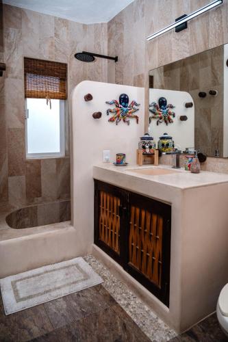 a bathroom with a sink and a shower and a tub at Ceiba Studios in Zihuatanejo