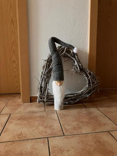 een klein poppetje in een krans op de vloer bij Ferienwohnungen Friedrich - im Herzen des Erzgebirges in Mildenau