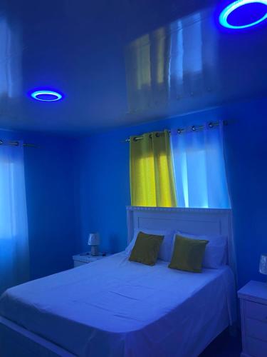 a blue room with a bed with a yellow curtain at Mi Rinconcito in Colorado