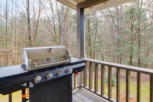 a grill on a deck with a view of the woods at 2 Mi to Lake Blue Ridge Yellowbird Cottage in Blue Ridge