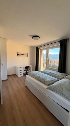 a bedroom with a large bed with a large window at Ferienwohnung Amseltraum in Seeboden