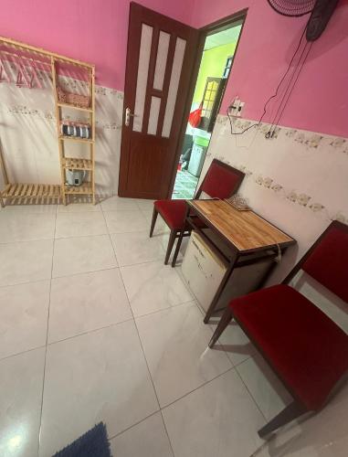 a room with a table and two chairs and a door at Song Anh Mui Ne Guesthouse in Mui Ne