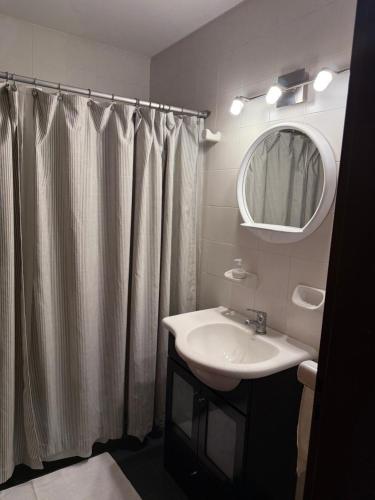 un bagno con lavandino e tenda da doccia di LPR EZE Airport a La Unión