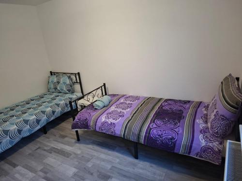 Una habitación con dos camas y una silla dentro. en Zwei separate Zimmer im 1 OG Ideal für Montüeren oder Studenten WG, en Siegen