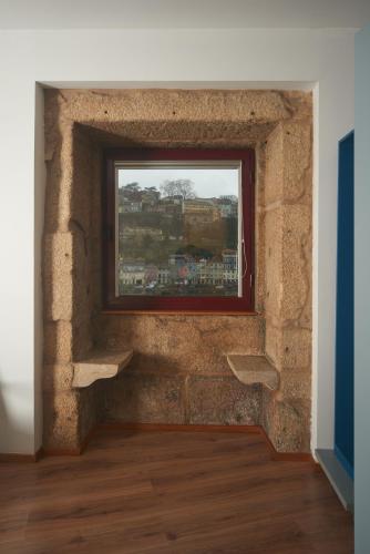 a brick wall with a window in a room at Bridge It - Suites & Views in Vila Nova de Gaia