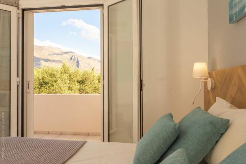 une chambre avec un lit et une porte coulissante en verre dans l'établissement Notos Villas, à Frangokastello